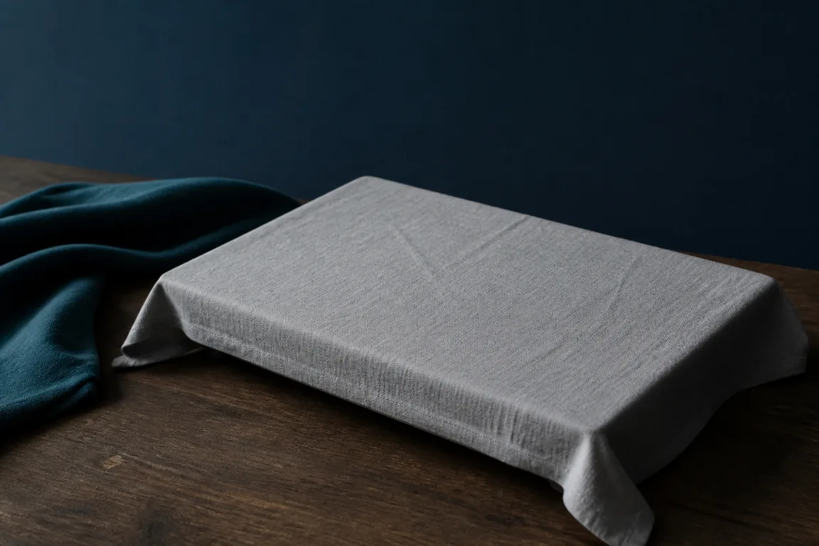 Laptop draped in linen in a dim navy room